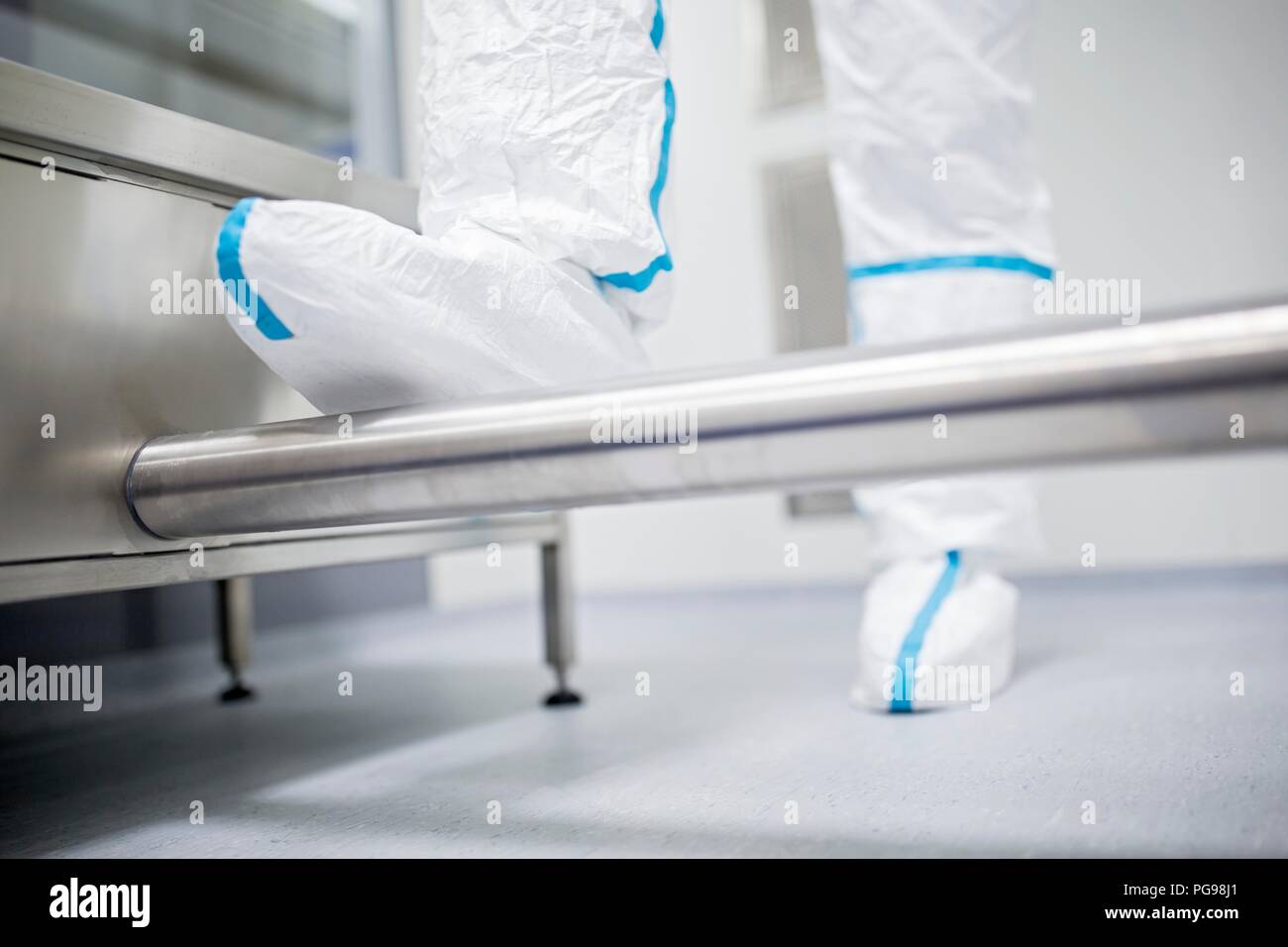 Nahaufnahme von einem Techniker zu Fuß durch eine Dekontaminierung Kabine vor dem Eintritt in ein steriles Labor. Stockfoto