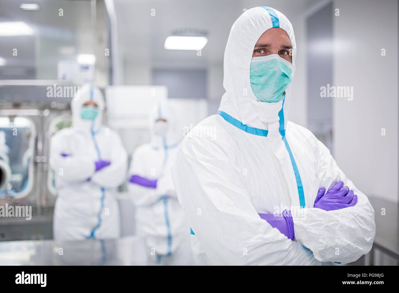 Labortechniker tragen Schutzanzüge und Gesichtsmasken im Labor, die in einem sterilen Umgebung erhalten. Stockfoto