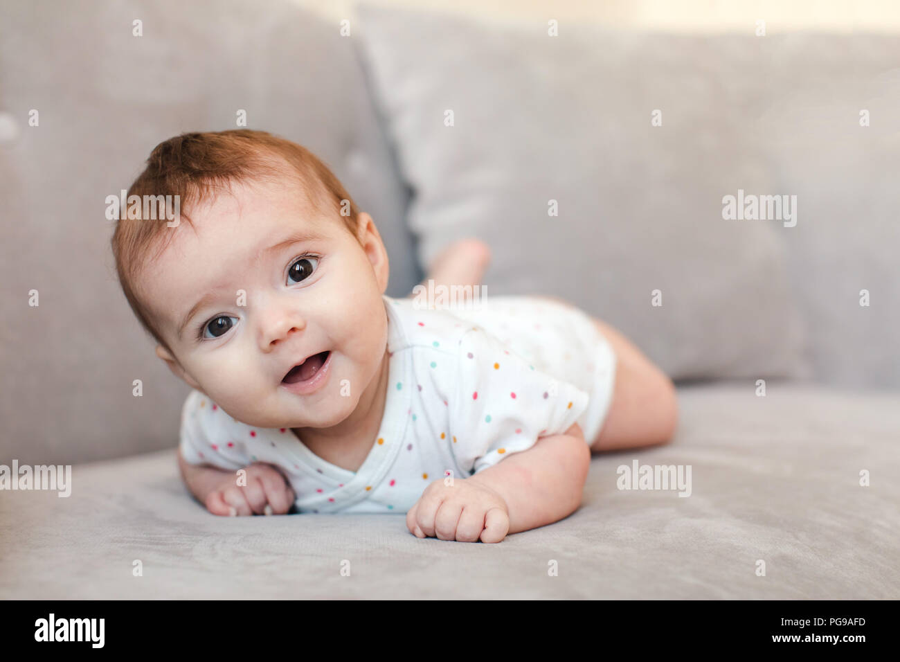 Baby liegend auf dem Sofa und Kamera Stockfoto