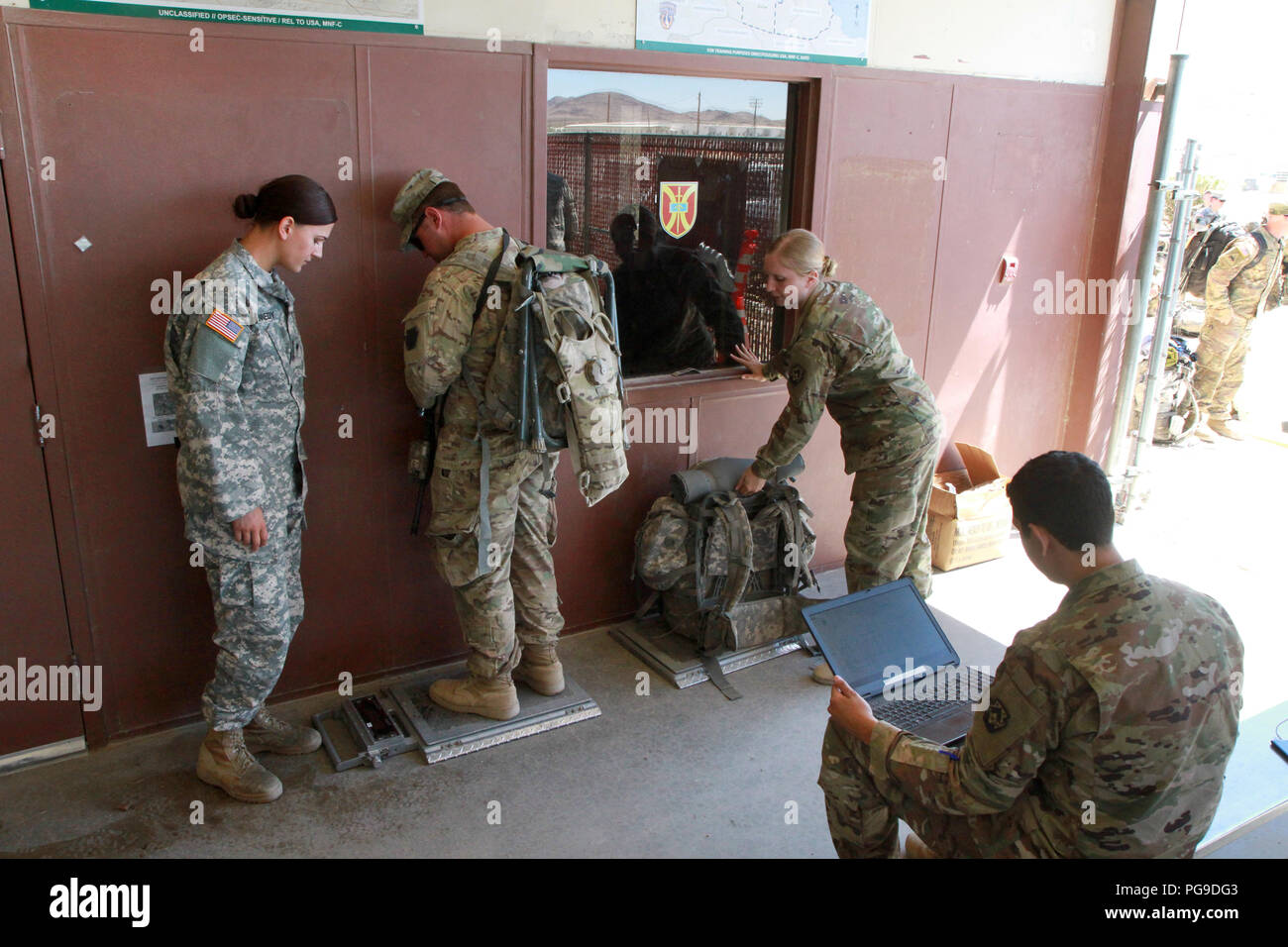 Spc. Kristine Kennedy (links), SPC. Hannah Beck (Mitte rechts) und Pvt. Juan Pastrana (rechts), alle Mitglieder der 213 Mitarbeiter Unternehmen, 213 Region Support Group, Pennsylvania Army National Guard, arbeiten zusammen, um out-Prozess 1 Battalion, 110Th Infantry Regiment, 56th Stryker Brigade Combat Team, 28 Infanterie Division Soldaten 12.08.23, Wiegen jeder Soldat und jeder tragen - auf und verstaut Kleidersack einen Flug Manifest für den Transport zurück nach Pennsylvania zu erstellen. (U.S. Army National Guard Foto von Sgt. Shane Smith/freigegeben) Stockfoto