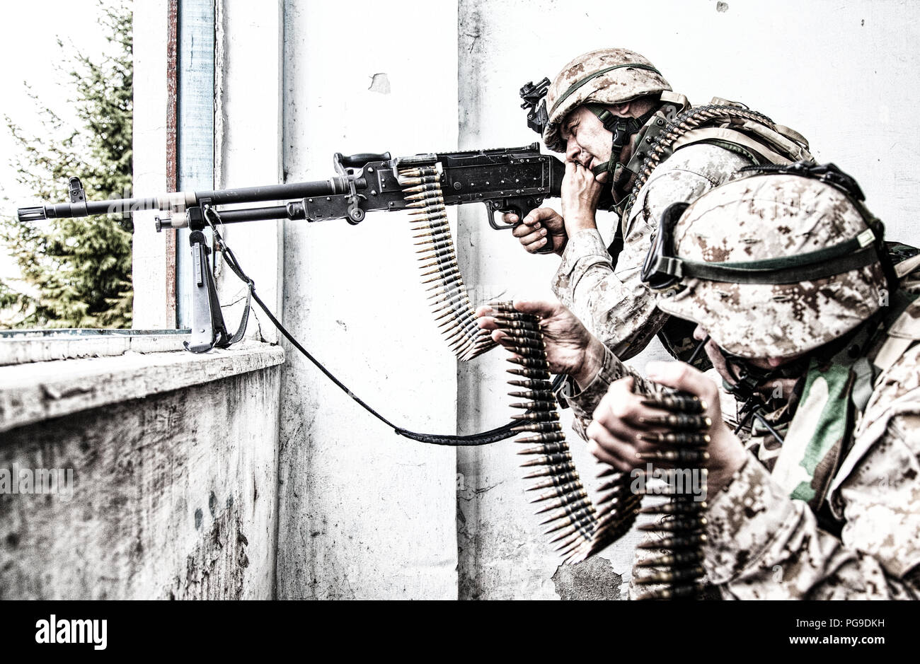 Armee machine gunner Angriffe Feind mit dem Ziel Feuer Stockfoto