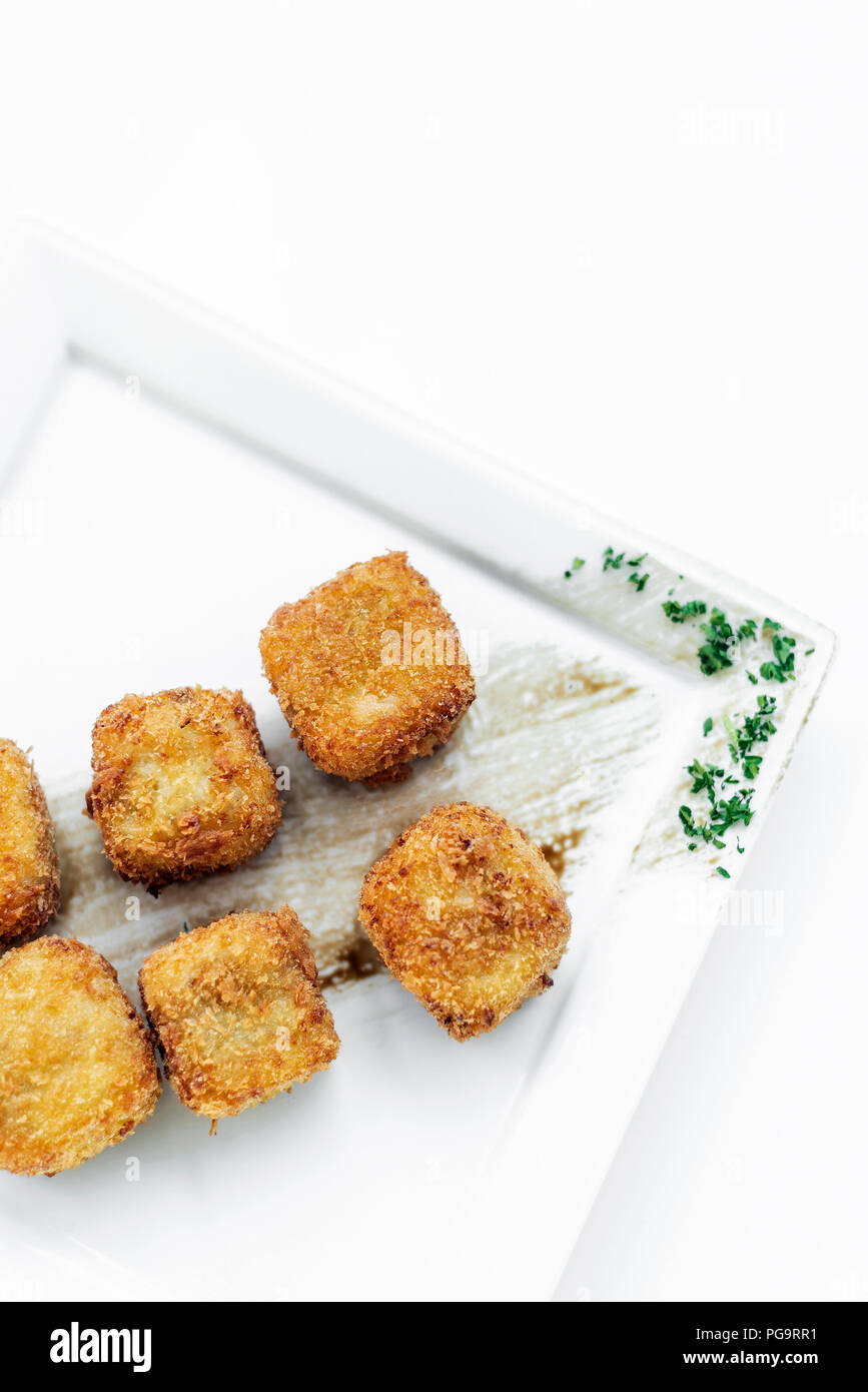 Frittierten Kartoffelbrei square Kroketten einfache vegetarische Beilage auf weiße Platte Stockfoto