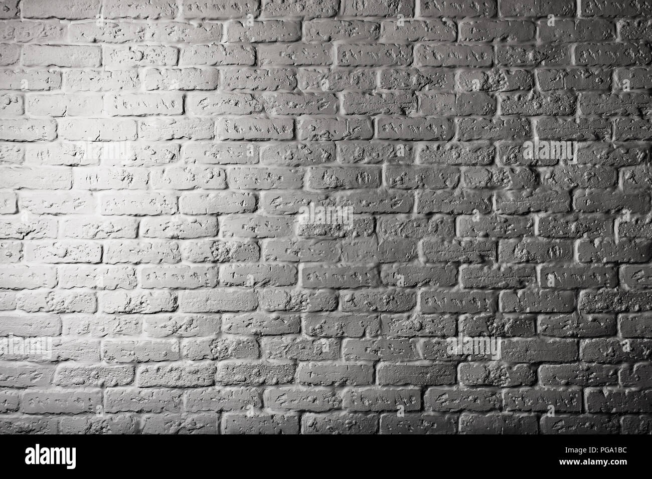 Teil eines Ziegelstein Mauer aus Stein mit Beleuchtung. Oberfläche der Mauer, die Hell auf der einen Seite leuchtet. Das Bild ist schwarz-weiß. Stockfoto