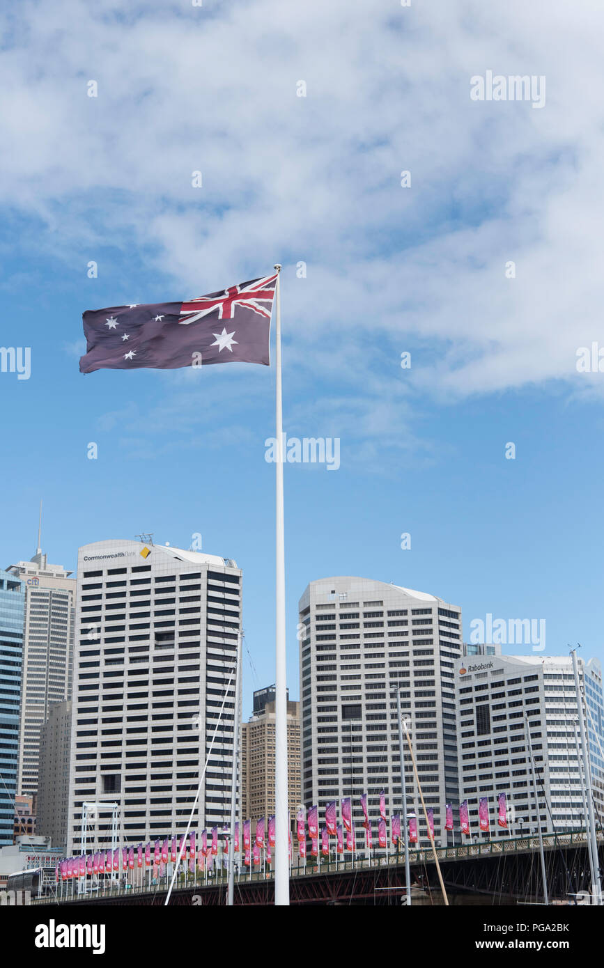 Australische Flagge in Darling Harbour fliegen mit Stadt hinter sich, und rosa Banner auf der Pyrmont Bridge New South Wales, Australien Stockfoto