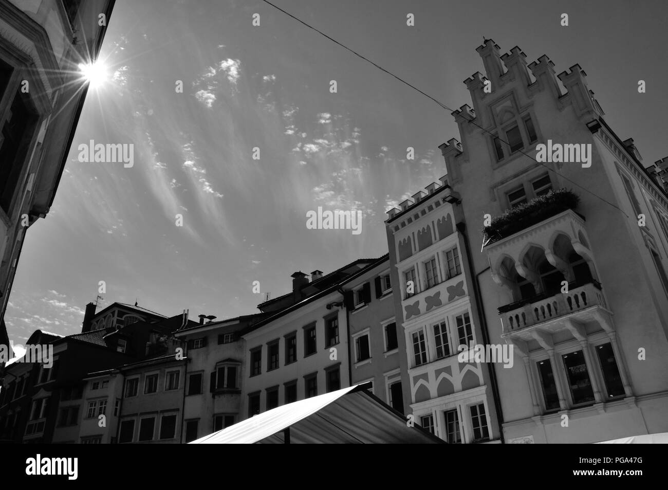 Die Strahlen der Sonne und der komische Wolken über der historischen Altstadt von Bozen, Südtirol, Italien, Monochrom Stockfoto