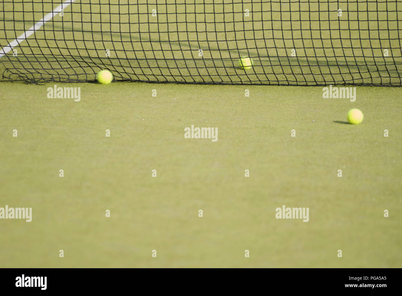 Drei gelbe Tennisbälle in der Nähe des Net. Fehler, Fehler, Schwierigkeiten Stockfoto