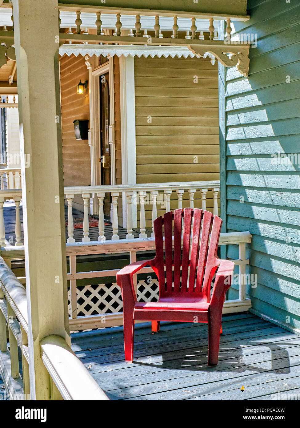 Leer einzelnen roten Stuhl, der auf einer Veranda in einem Wohnviertel von Montgomery Alabama, USA. Stockfoto