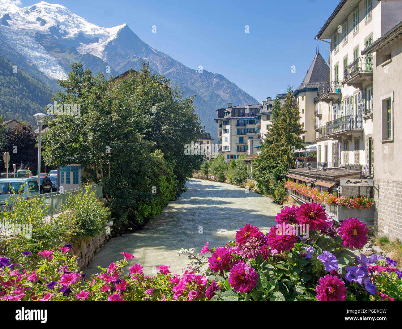 CHAMONIX, Haute Savoie, Frankreich August 23, 2018: Das Zentrum von Chamonix Mont Blanc und den Fluss Arve, mit Blumen im Sommer und die Alpen im Hintergrund. Beliebte Jahr für Winter- und andere Sportarten. Stockfoto