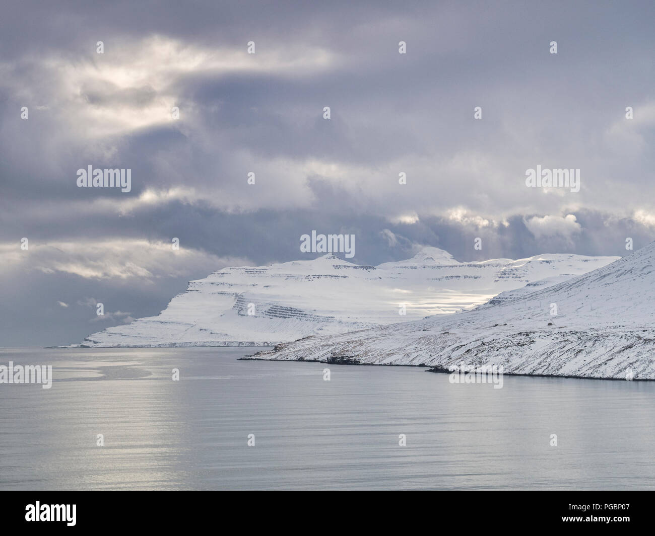 Snowy Mountains in Islands östlichen Fjorden unter einem Moody Himmel. Stockfoto