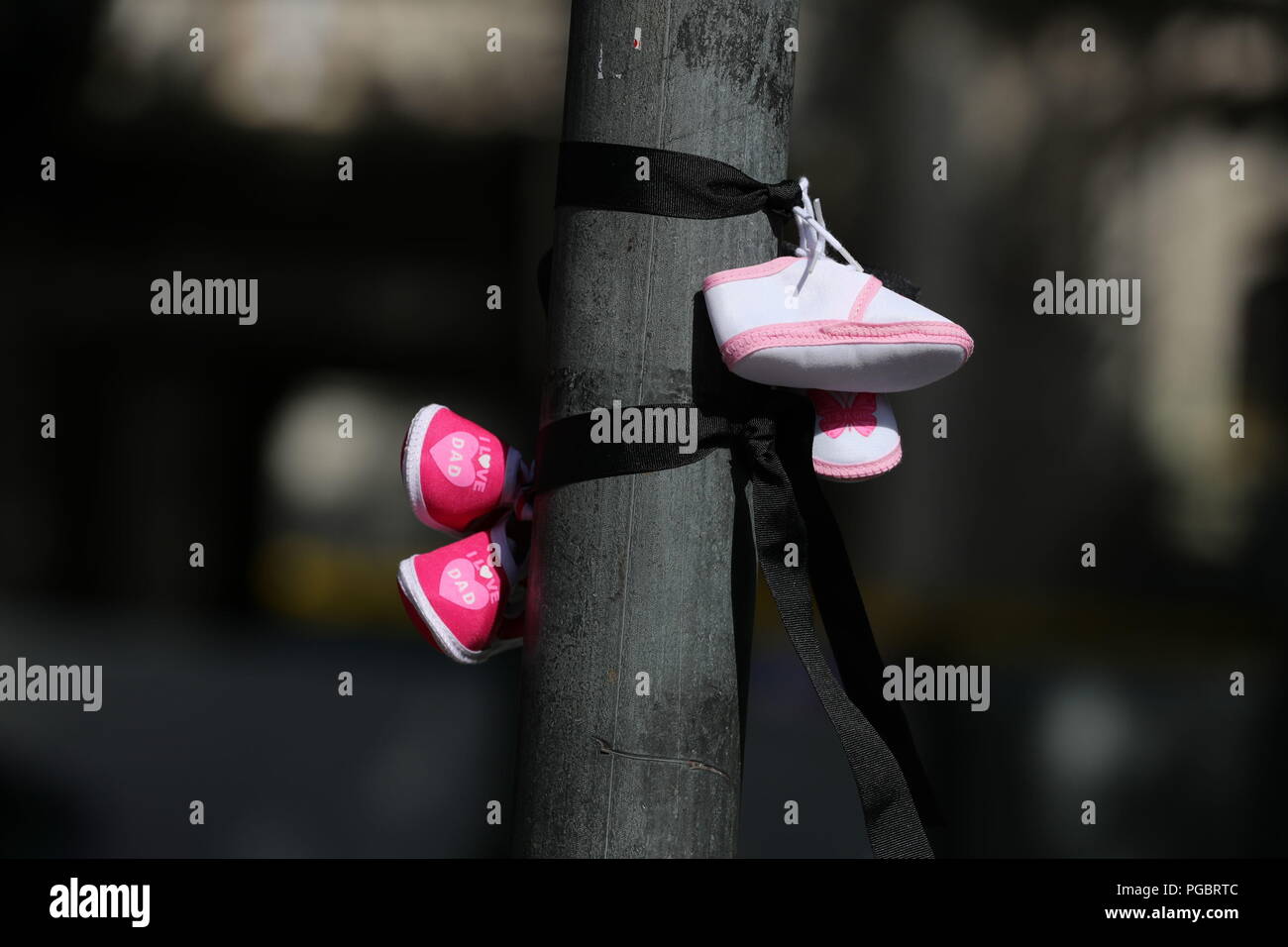 Demonstranten Riegel Baby Schuhe auf einen Posten, was bedeutet, dass die Kinder, die in der Mutter und Kind Wohnungen in Irland starben, während eines Protestes in Dublin vor Beginn des Besuchs in Irland von Papst Franziskus. Stockfoto