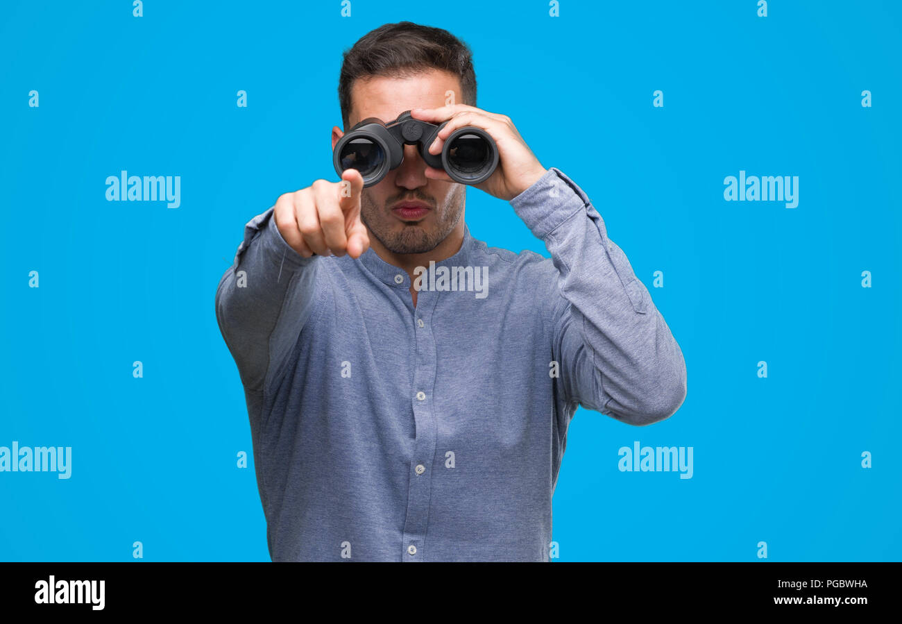 Hübscher junger Mann durch ein Fernglas, mit dem Finger auf die Kamera und  zu Ihnen zeigt suchen, Handzeichen, positiv und zuversichtlich Geste von  vorne Stockfotografie - Alamy