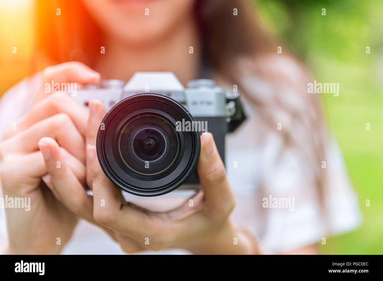 Closeup Frontlinse des spiegellosen Kamera in Frau jugendlich Fotograf Stockfoto