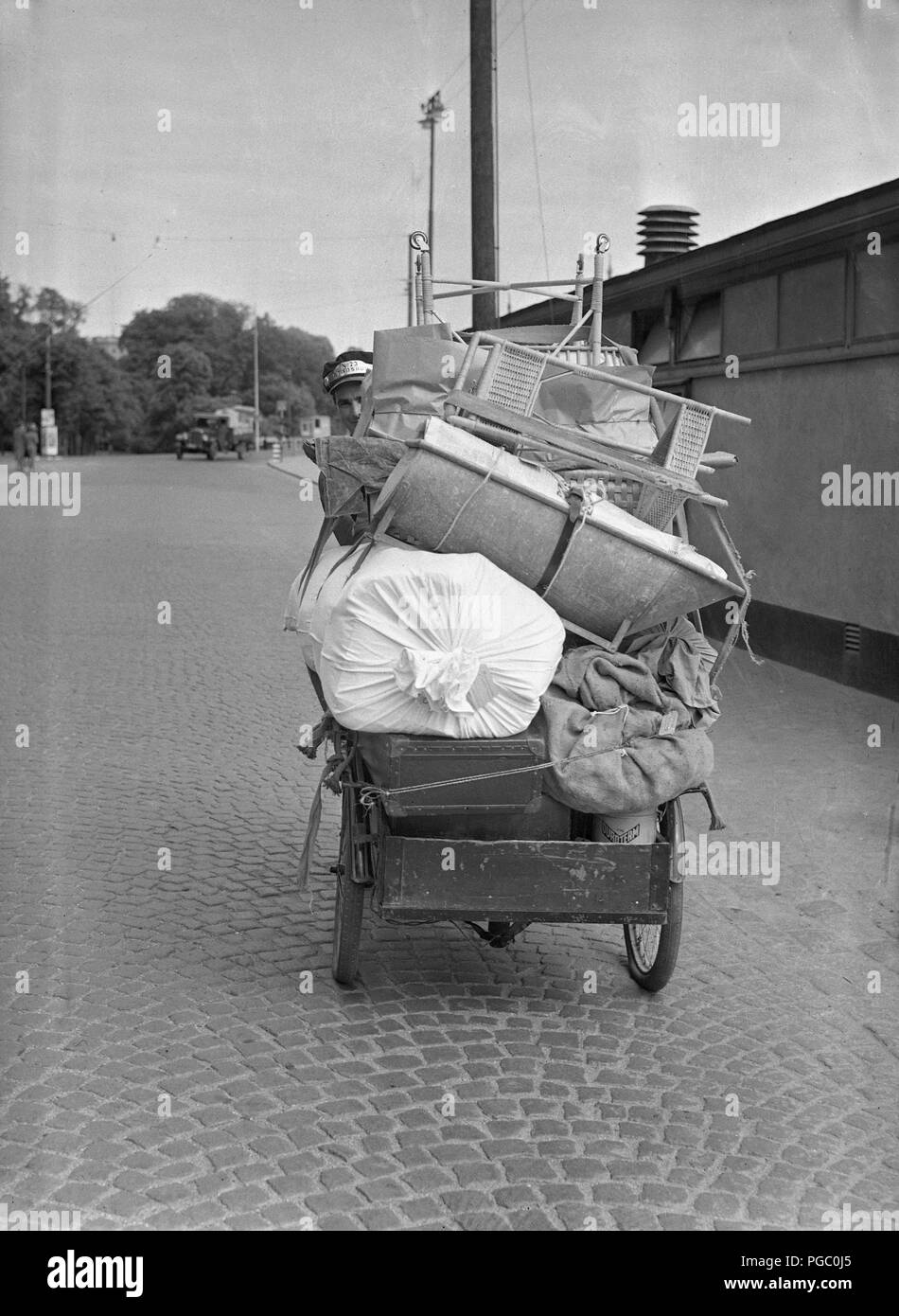 1940 s Transport. Ein junger Mann arbeitet als Fahrrad messanger und Transportieren von Gütern in die Stadt Stockholm mit seinem Transport fahrrad. Juni 1940. Foto Kristoffersson 146-8 Stockfoto