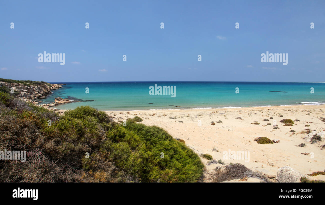 Schöne leere unberührten feinen Sandstrand mit keine Menschen, die Aussicht von der Spitze des Hügels ruhiges Meer zu Azure. Karpass (karpaz) Region, Nordzypern. Stockfoto