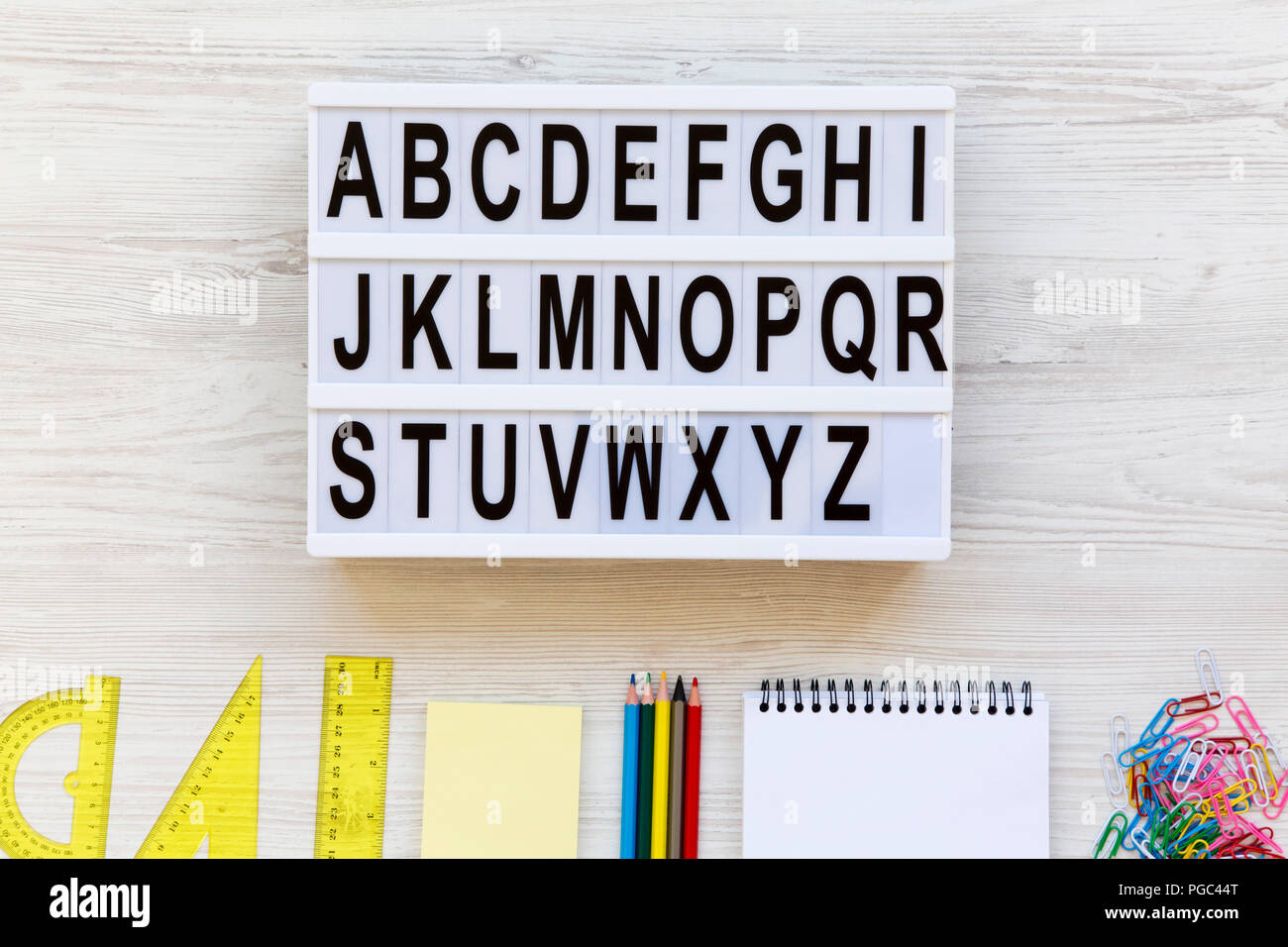 Bildung Konzept. Buchstaben von A bis Z des englischen Alphabets auf modernen Board und Zubehör für Studie über weiß Holz- Hintergrund, Ansicht von oben. Von einem Stockfoto
