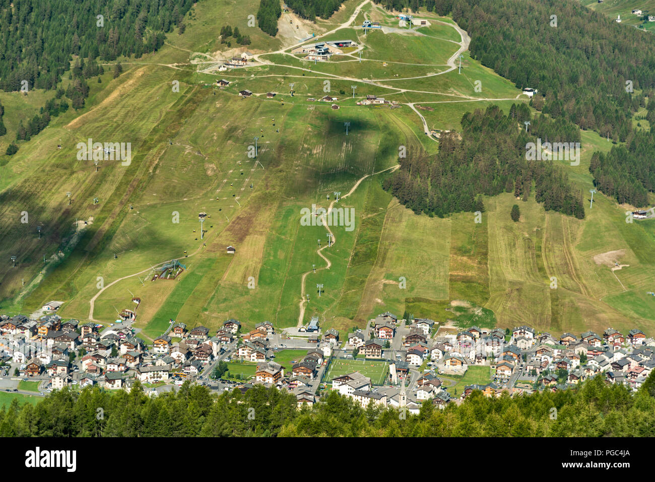 Luftaufnahme des Skigebiet Livigno in den italienischen Alpen, Lombardei, eingebettet in ein Tal von lushgreen einen steilen Berg gesehen Stockfoto