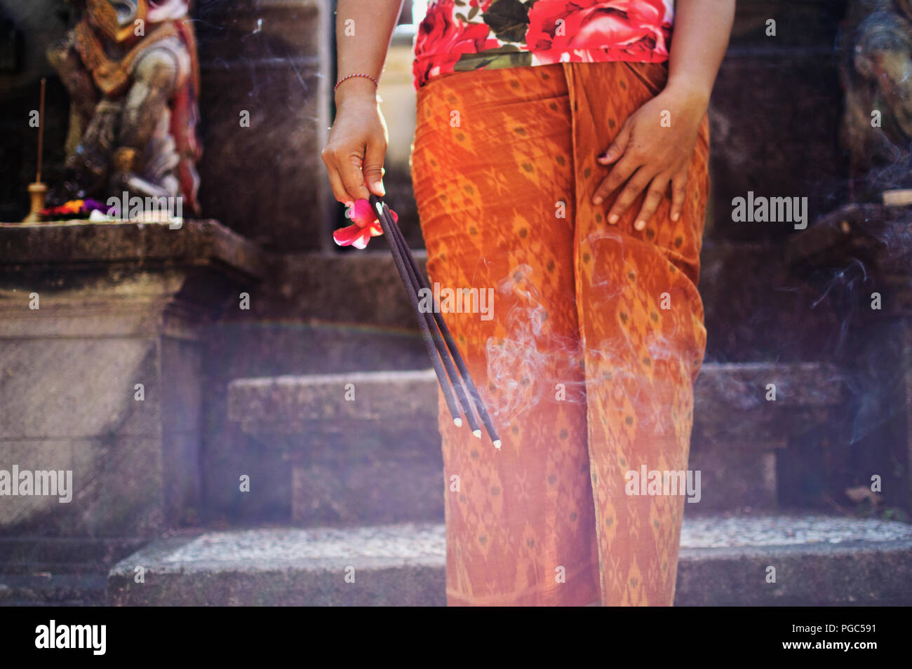 Schöne asiatische Frau mit Räucherstäbchen und zu beten, während der hinduistischen Zeremonie in einem Tempel auf Bali, Indonesien Stockfoto