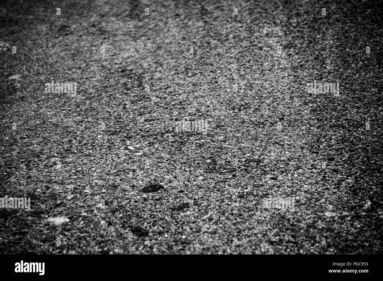 Klare Welle ausdehnen auf dem Kies Sand in Schwarz und Weiß. Sie können sehen, Sand Textur auf die Erde, und alle clarities von Wasser. Stockfoto