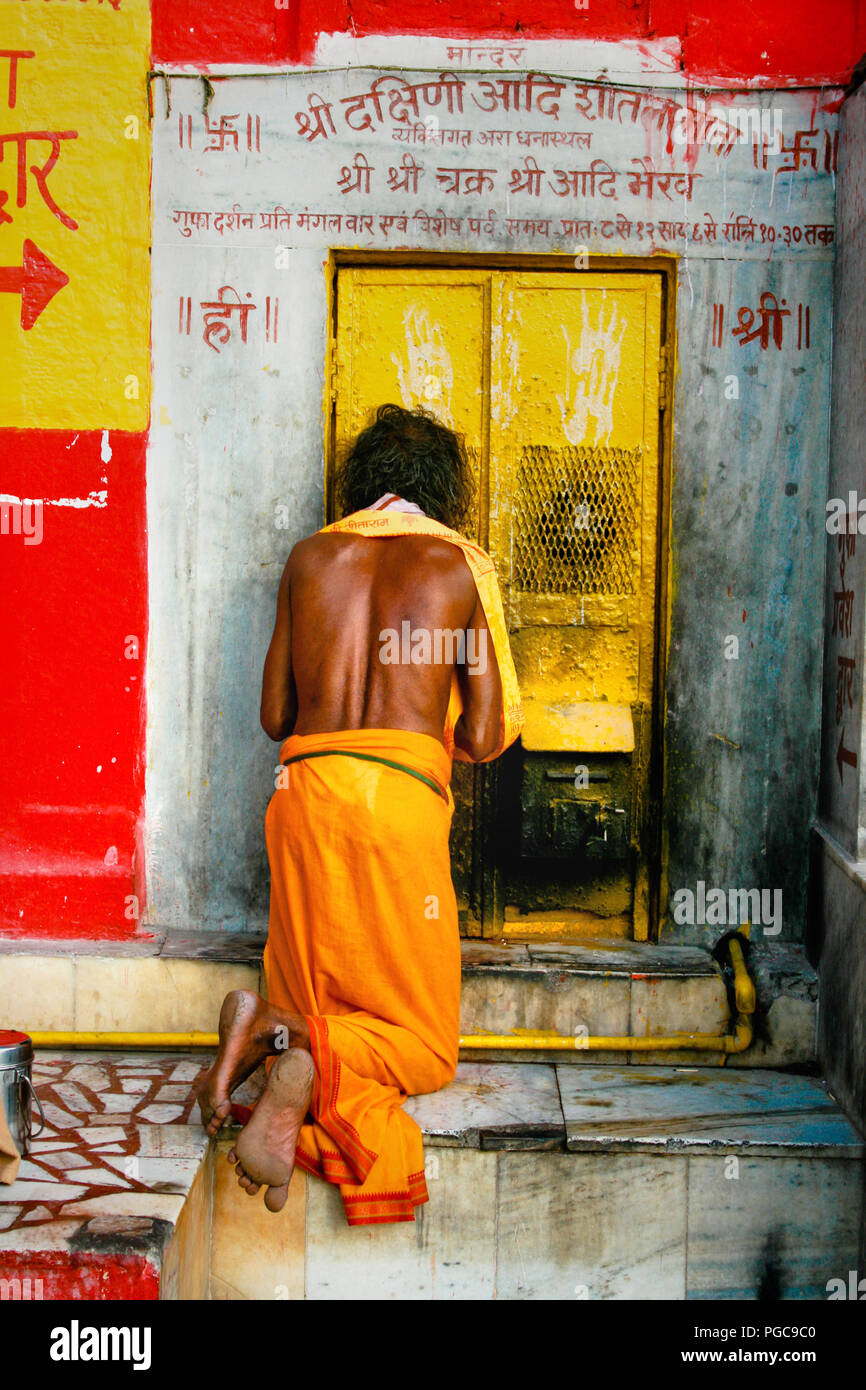 Ein Mann parays vor der Tür des Tempels in Varanasi, Indien Stockfoto