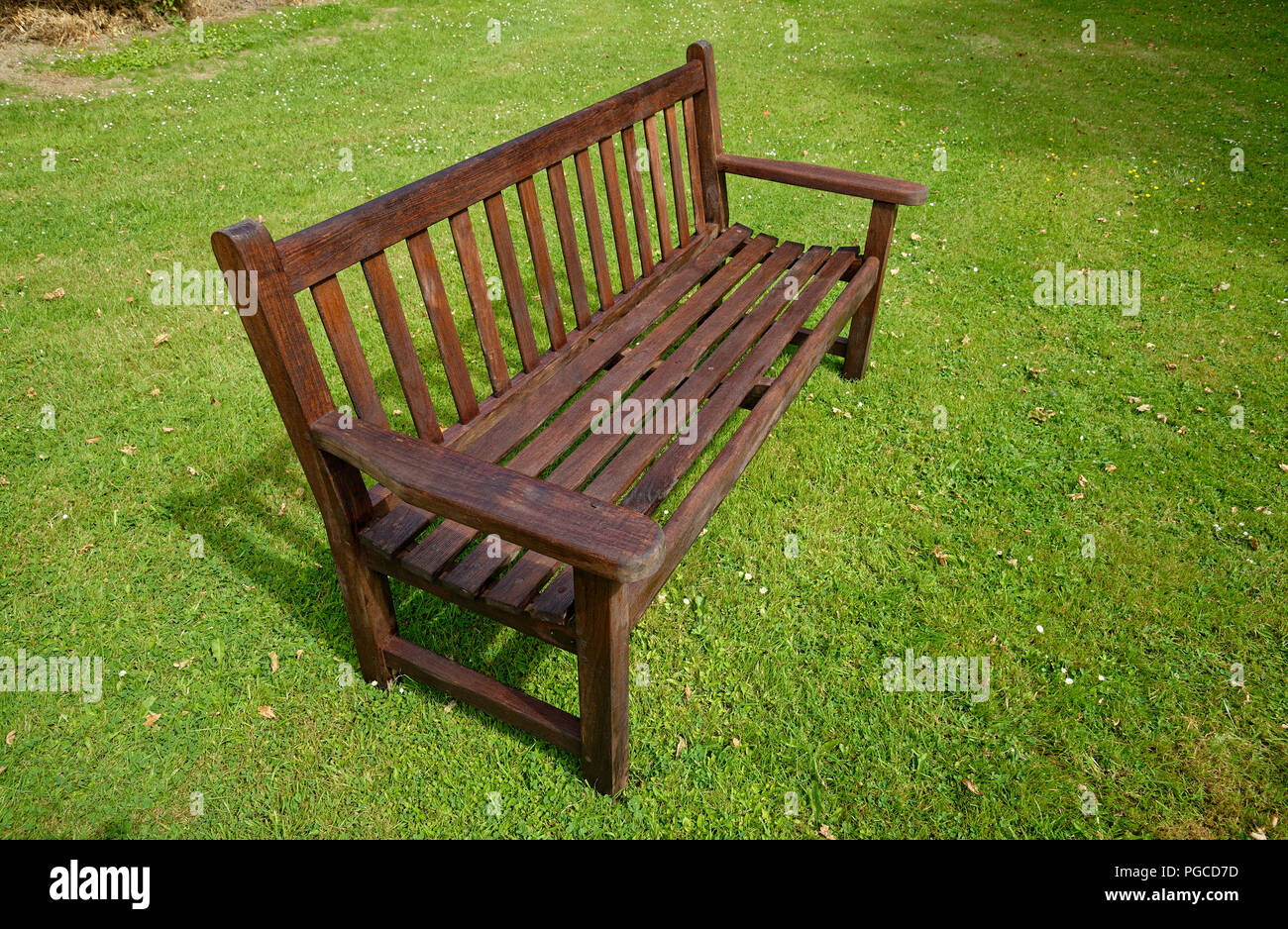 Wodd Garten Bank auf einem grünen gemähten Rasen. Stockfoto