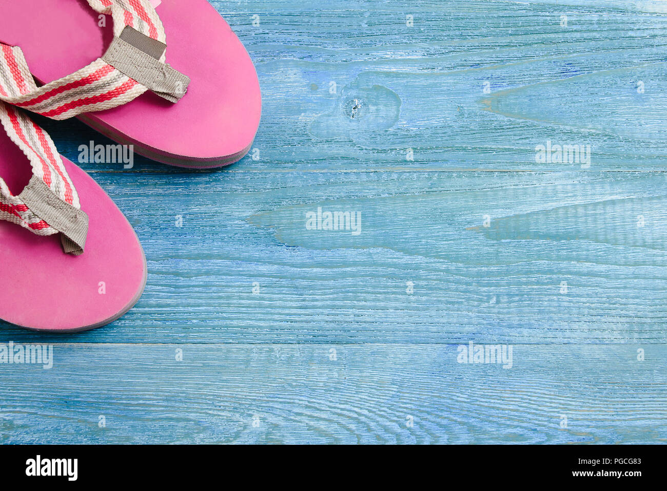 Rosa Hausschuhe auf einem blauen Hintergrund Hintergrund Holz, Sommer und Urlaub Konzept Stockfoto