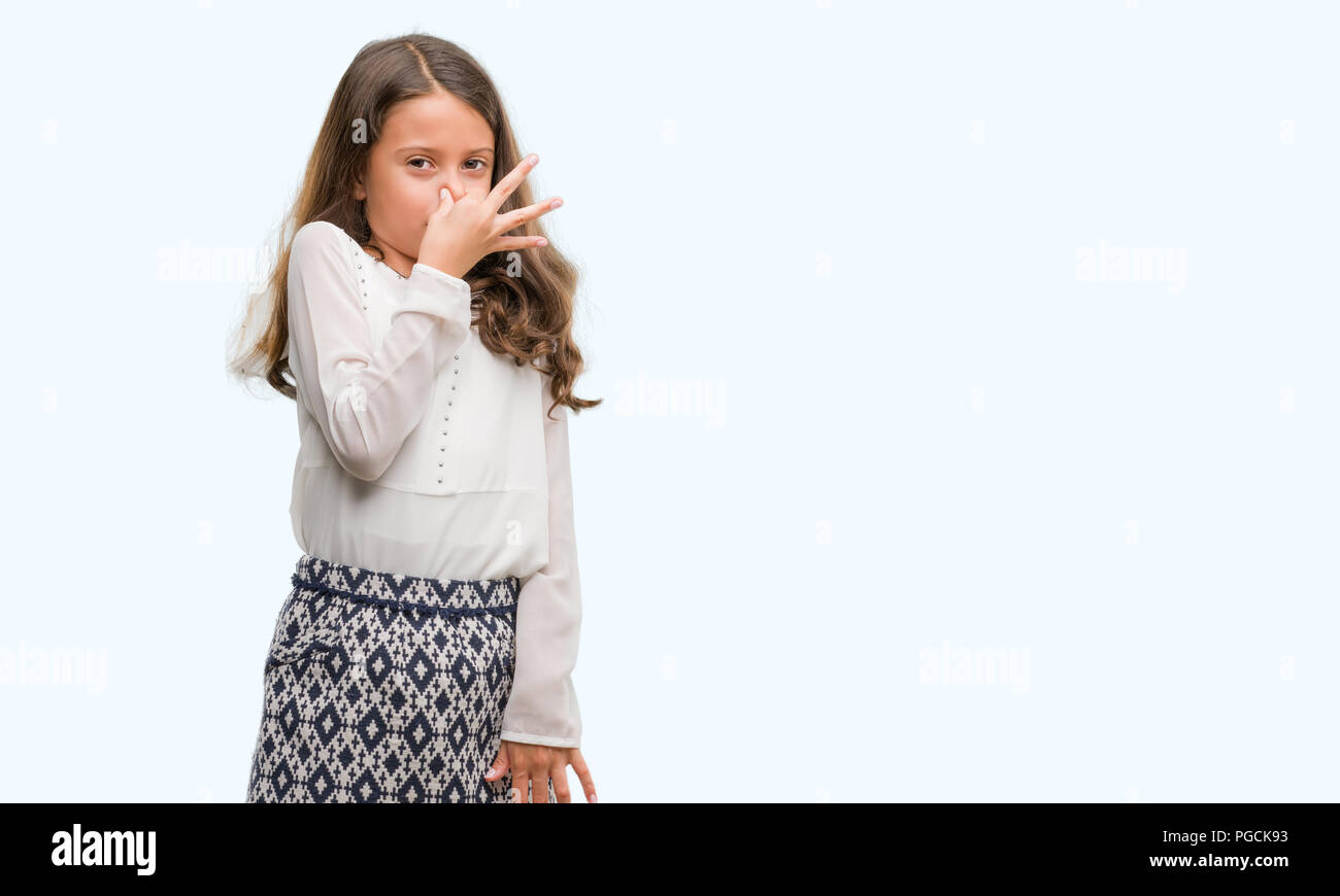 Brunette hispanische Mädchen riechen etwas stinkig und ekelhaft, unerträglichen Geruch, Atem wird mit dem Finger auf die Nase. Schlechte Gerüche Konzept. Stockfoto