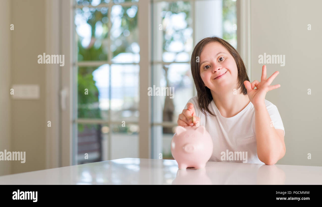 Down Syndrom Frau zu Hause holding Sparschwein tun ok