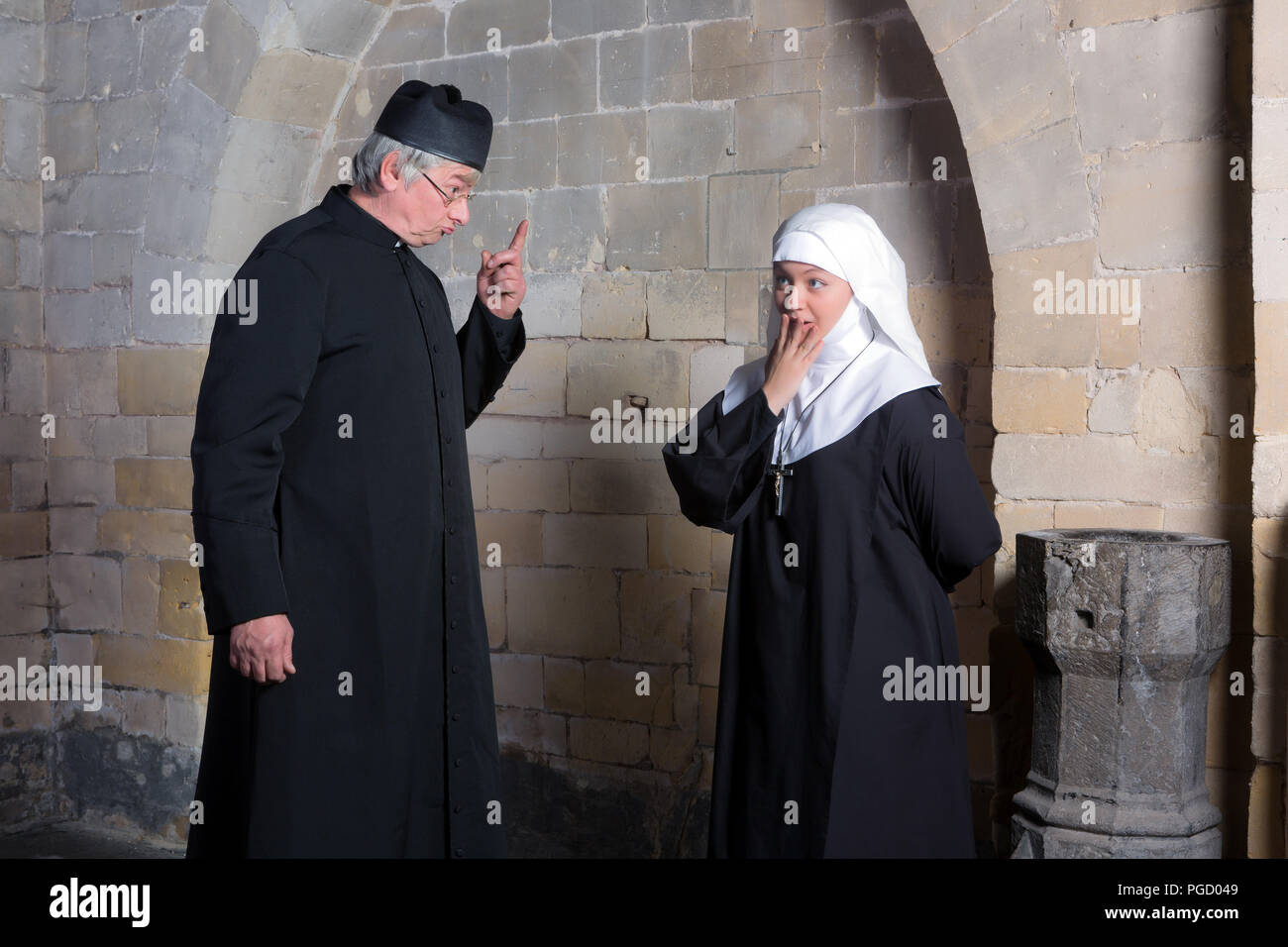 Priester, die eine junge Novizin eine Rüge Stockfoto