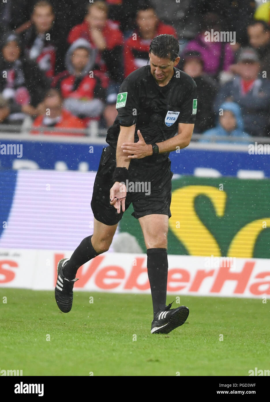 Freiburg, Deutschland. 25 Aug, 2018. Fussball, Bundesliga, SC Freiburg vs Eintracht Frankfurt, 1.Spieltag in der Schwarzwaldstadion. Schiedsrichter Manuel Graefe Punkte an seinen Arm nach einem Video prüfen. Quelle: Patrick Seeger/dpa - WICHTIGER HINWEIS: DFL Regelungen die Verwendung von Fotografien als Bildsequenzen und/oder quasi-Video./dpa/Alamy Leben Nachrichten verbieten Stockfoto