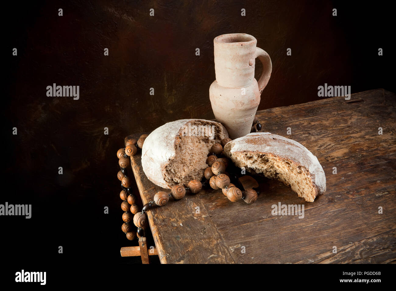 Antiker Rosenkranz und Wein Krug mit einem rustikalen Laib Brot Stockfoto