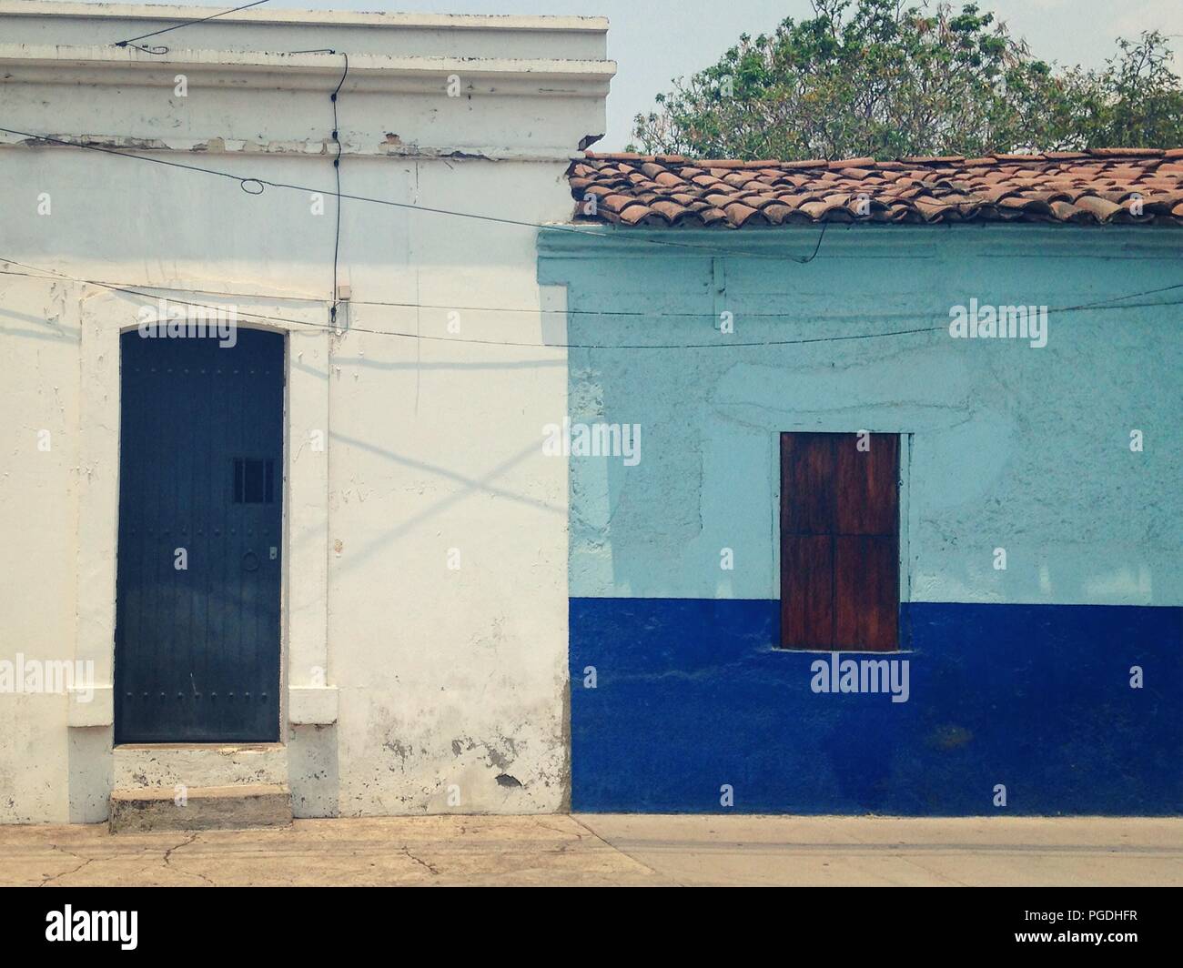 Haus im Kolonialstil mit Holztür umgeben. Guadalajara, Mexiko Stockfoto