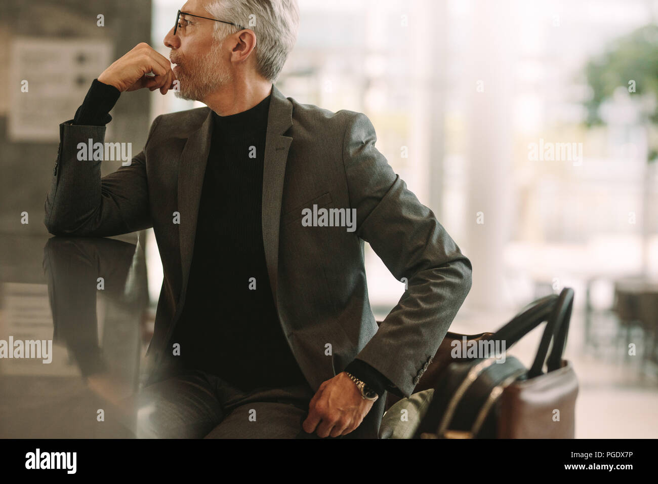 Portrait von älteren Geschäftsmann im Cafe sitzen. Älterer Mann im Anzug weg schauen, während im Café sitzen. Stockfoto