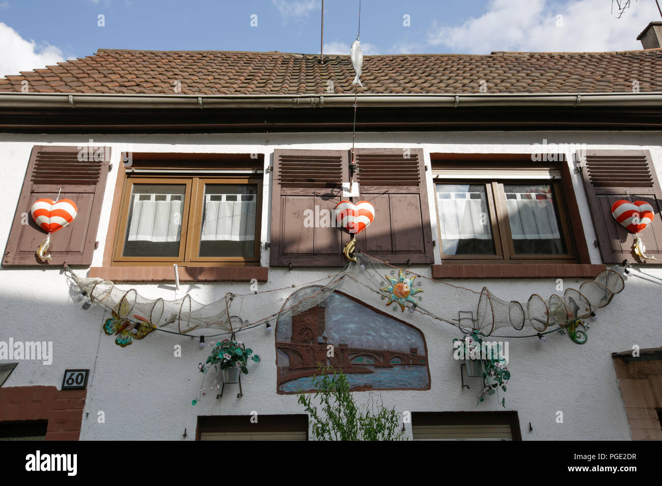 Worms, Deutschland. 25 Aug, 2018. Ein Haus in der fishermenÕs Fischerwaad (LEA), wo die Fischer in der Vergangenheit zu leben, mit dem traditionellen Wahrzeichen der Backfischfest, den roten und weißen Herzen und Werkzeuge der Fischer dekoriert ist. Der größte Wein- und Volksfest am Rhein, das backfischfest in Worms begann mit der traditionellen Übergabe der Macht aus dem Oberbürgermeister, dem Bürgermeister der fishermenÕs Lea. Die Zeremonie wurde von Tänzen und Musik umrahmt. Quelle: Michael Debets/Pacific Press/Alamy leben Nachrichten Stockfoto