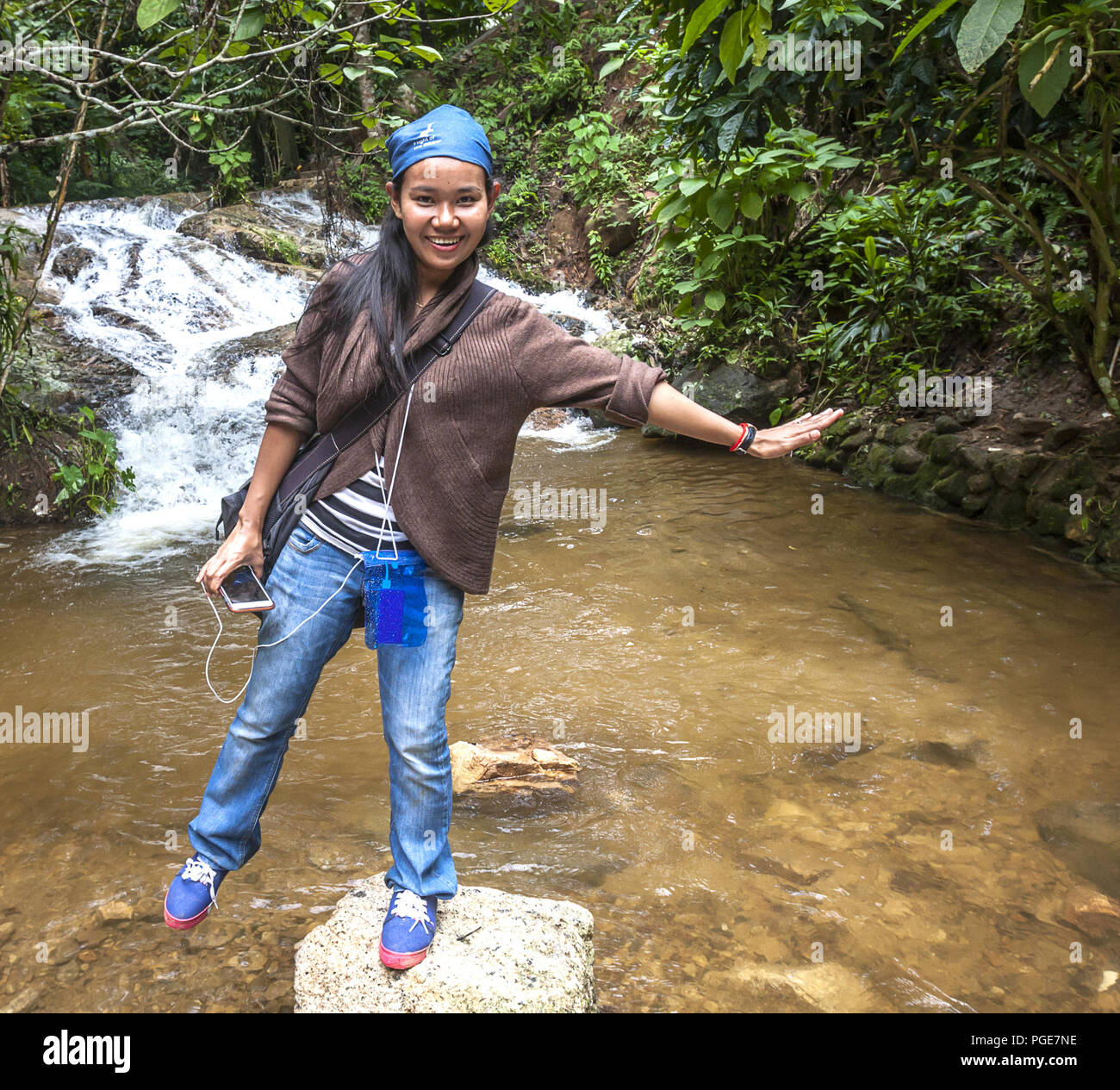 Asiatische Frau Balancieren auf einem Felsen in der Mitte eines Streams, nördlich von Chiang Mai in den Bergen. Mit Photo: Ja Stockfoto