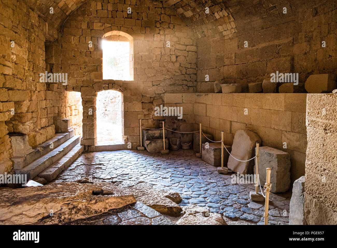 Das ist ein Bild von einer Kammer in einer mittelalterlichen Burg in Rhodos Griechenland. Das Licht strahlt in aus dem Stein Fenster eine sehr atmosphärische Szene schafft. Stockfoto