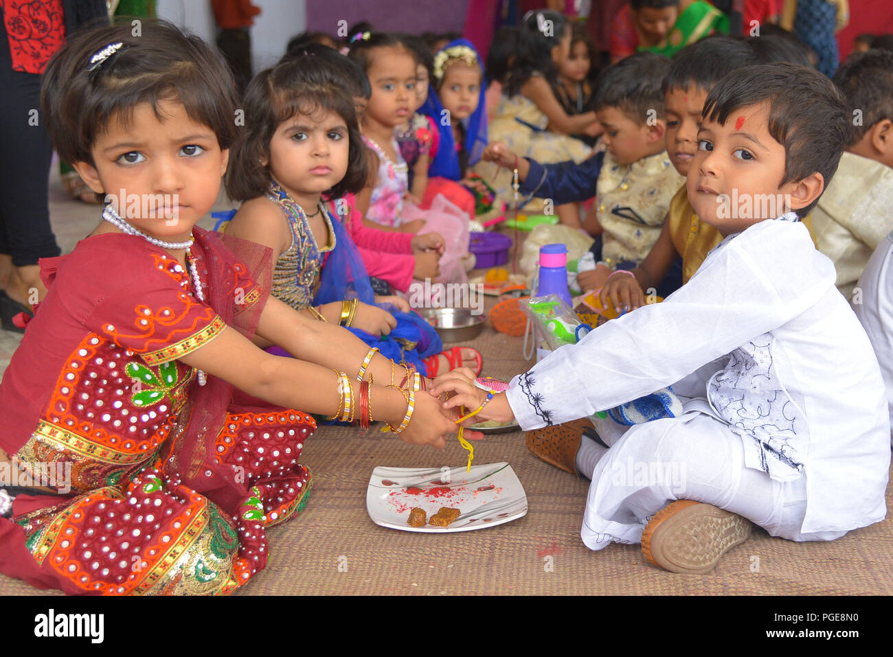 Ajmer, Indien. 25 Aug, 2018. Ein indisch-hinduistischen Mädchen Bindungen rakhis, oder heilige Gewinde, am Handgelenk ihres Bruders als symbolische Geste während der "Raksha Bandhan' Festival in Ajmer, Rajasthan, Indien, 25. August 2018. "Raksha Bandhan' feiert das Verhältnis zwischen den Brüdern und Schwestern. Foto von shaukat ahmed Credit: shaukat Ahmed/Pacific Press/Alamy leben Nachrichten Stockfoto
