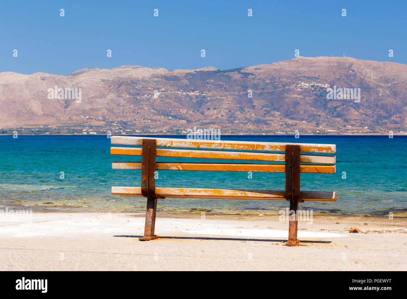 Schöne Sitzbank sitzen direkt am Meer mit atemberaubendem Blick vor einem blauen Himmel und Meer in Elafonisos Island, Griechenland Stockfoto