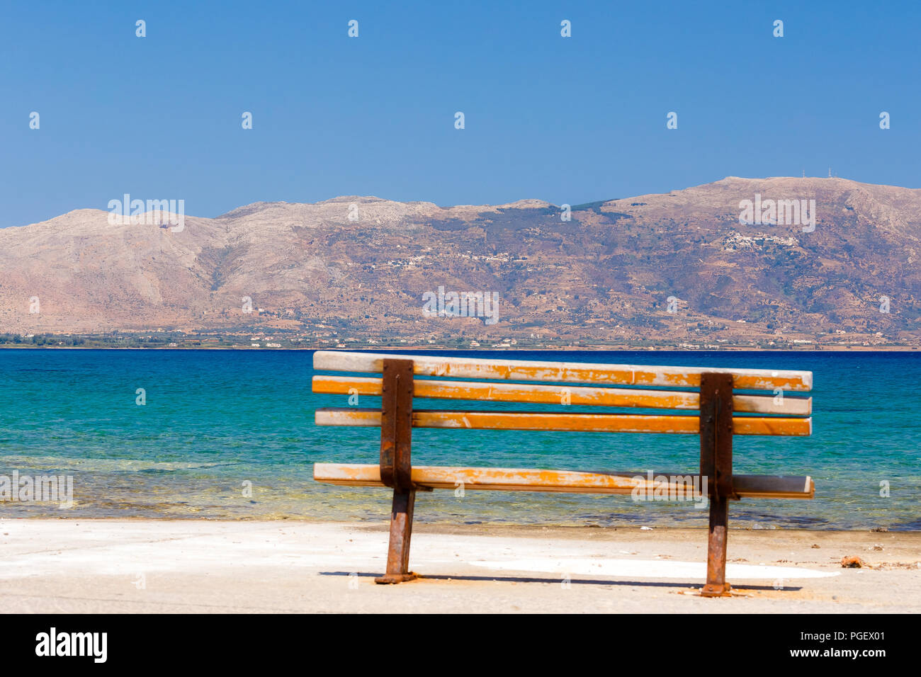Schöne Sitzbank sitzen direkt am Meer mit atemberaubendem Blick vor einem blauen Himmel und Meer in Elafonisos Island, Griechenland Stockfoto
