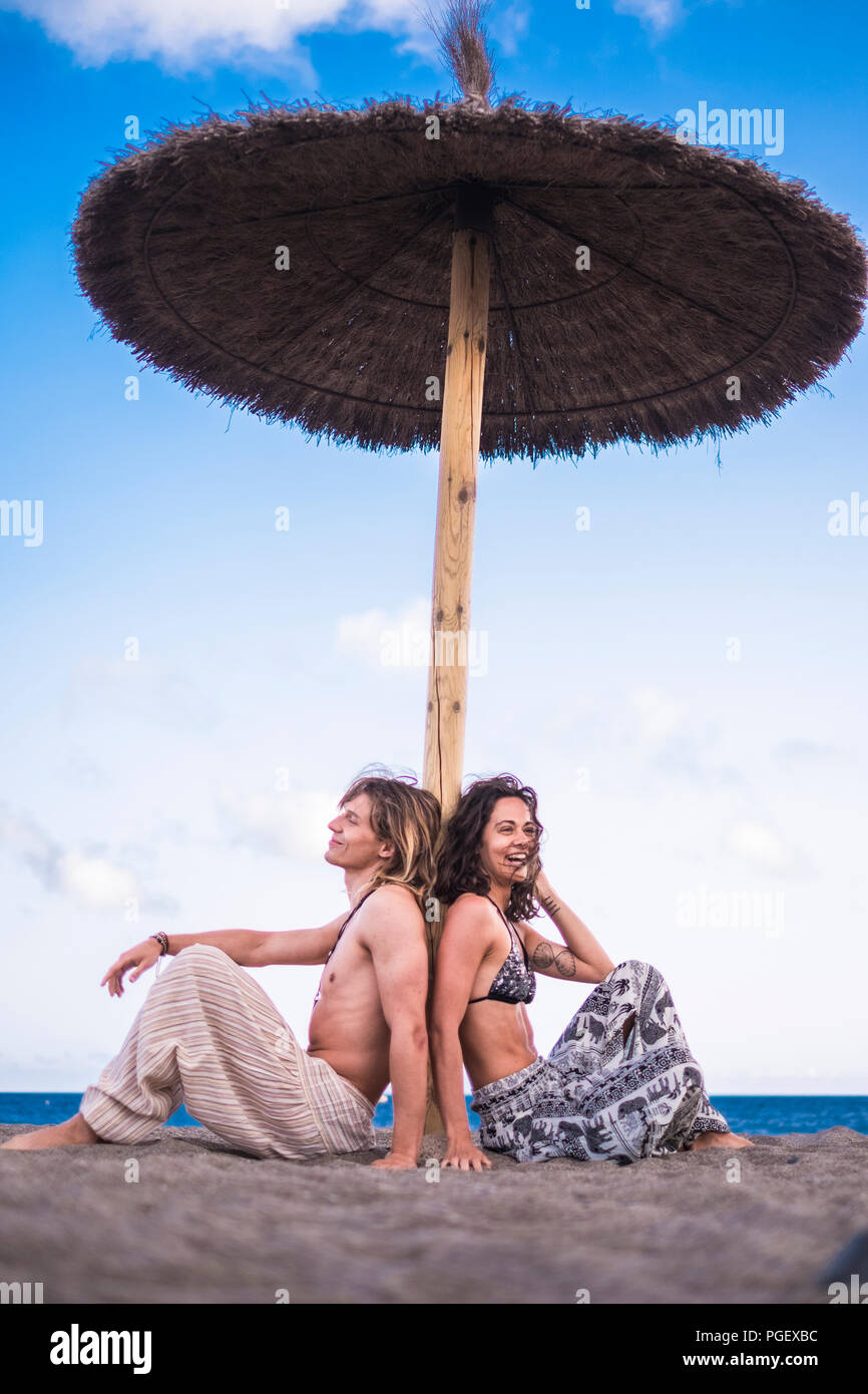 Schöne und fröhliche kaukasischen junges Paar Mann Frau unter einem Sonnenschirm am Strand sitzend geniessen Urlaub und im Sommer Freizeitaktivitäten Aktivitäten Stockfoto Schöne und fröhliche kaukasischen junges Paar Mann Frau unter einem Sonnenschirm am Strand sitzend geniessen Urlaub und im Sommer Freizeitaktivitäten Aktivitäten Stockfoto