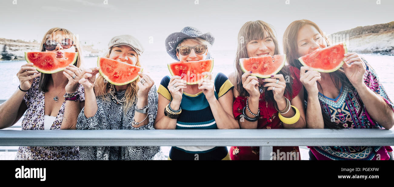 Aufenthalt Gruppe von Nizza cute fröhlicher junger Frauen Freunde zusammen Spaß und Freundschaft unter einem roten Wassermelone in der Nähe des Gesichts. Stockfoto