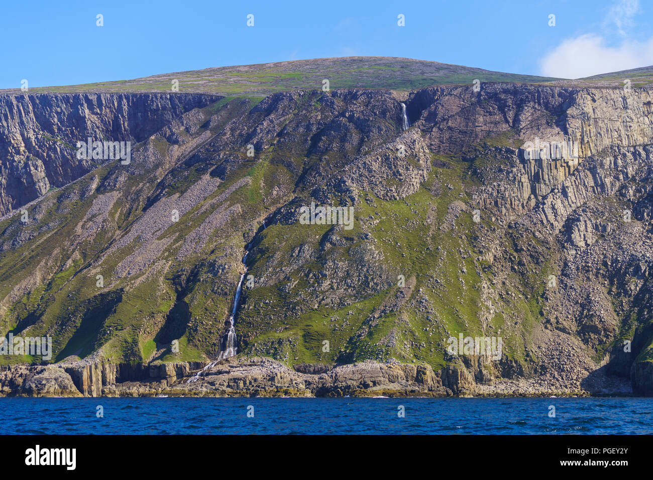 Ein Wasserfall Kaskaden hinunter das Gesicht eines Sea Cliff auf der Insel Rum. Rum ist eine der kleinen Inseln der Inneren Hebriden in Schottland. Stockfoto