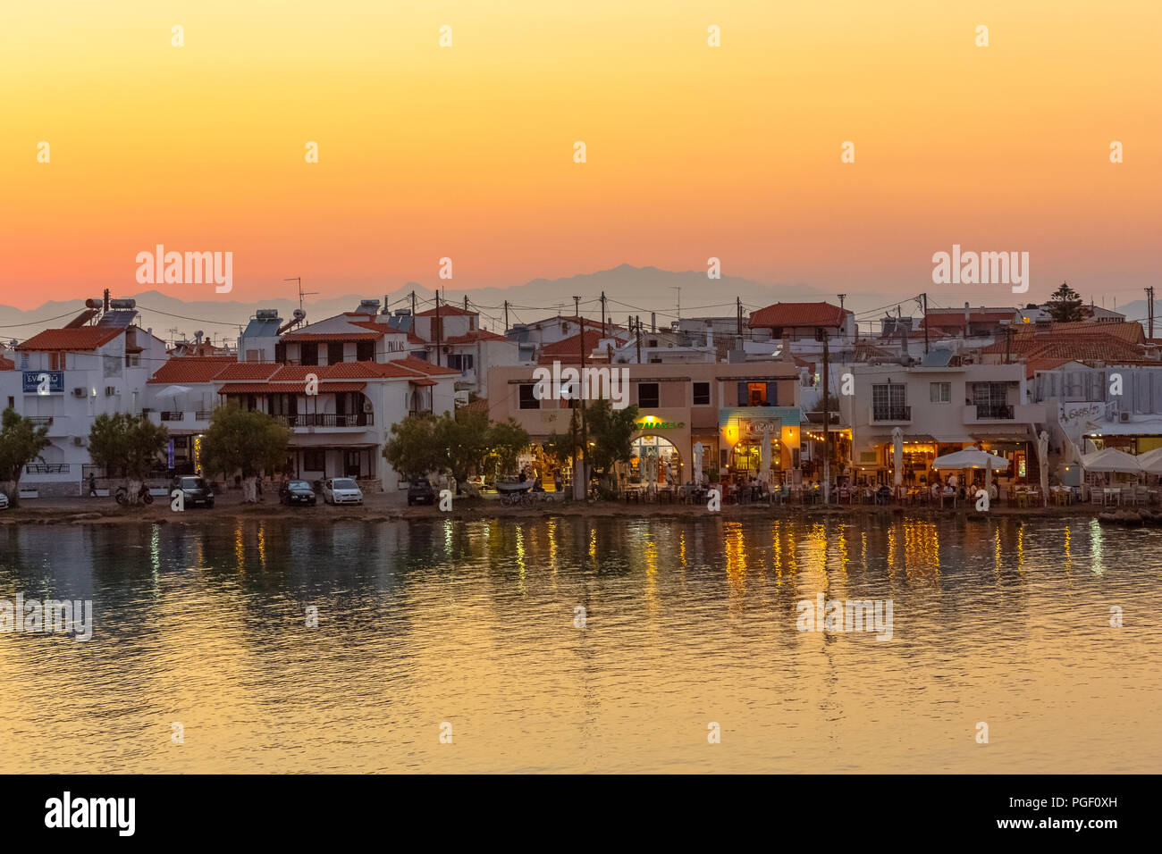 Elafonisos Stadt im Abstand am Nachmittag mit Restaurants und Meer Reflexionen in Lakonien, Peloponnes, Griechenland Stockfoto