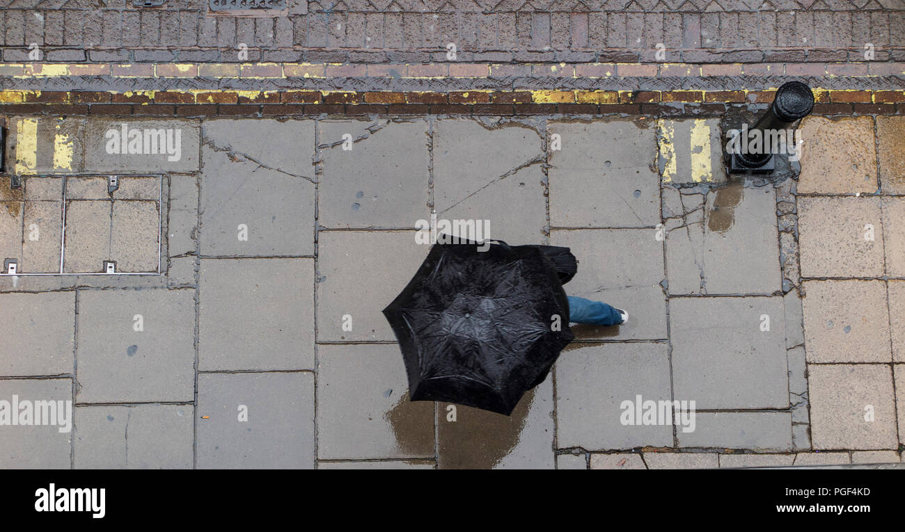 Regen- und Sonnenschirme werden angehoben, trocken auf einer Londoner Straße zu halten. Stockfoto