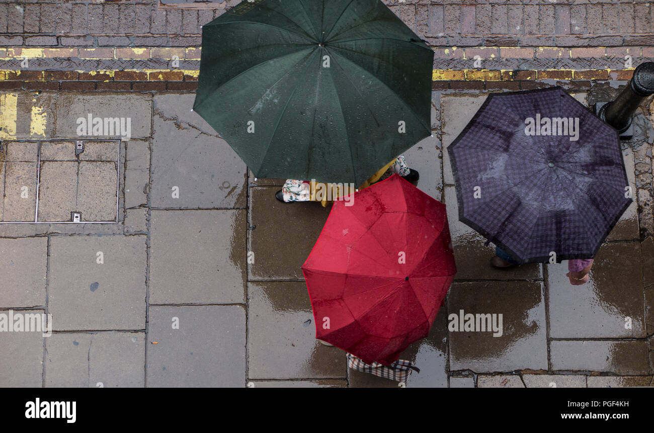 Regen- und Sonnenschirme werden angehoben, trocken auf einer Londoner Straße zu halten. Stockfoto