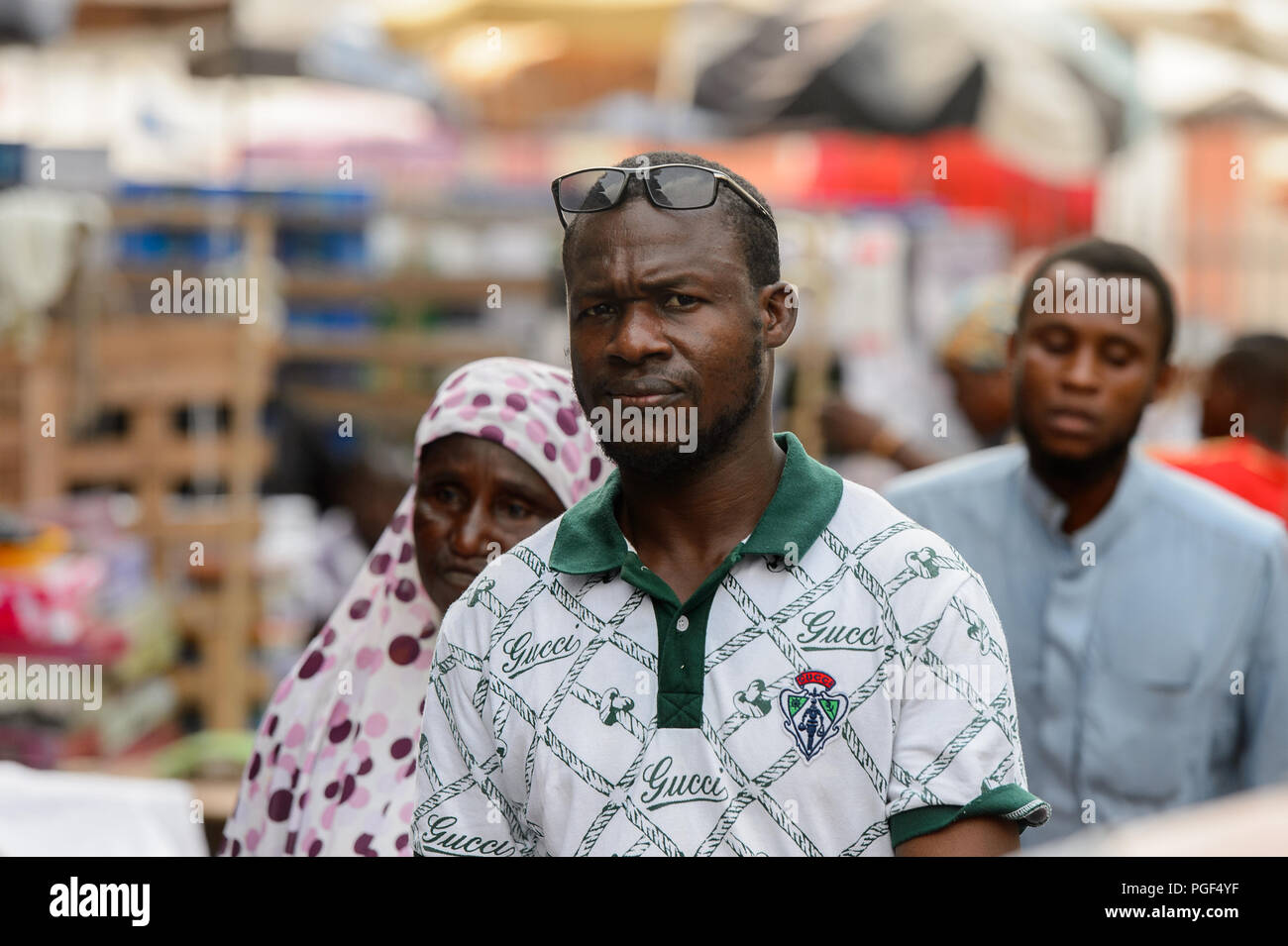 LOME, TOGO - Jan 9, 2017: Unbekannter togoischen Mann trägt eine Sonnenbrille und Gucci Shirt an dem Abkommen von Lome zentralen Markt. Togo Menschen leiden unter der Armut aufgrund Stockfoto