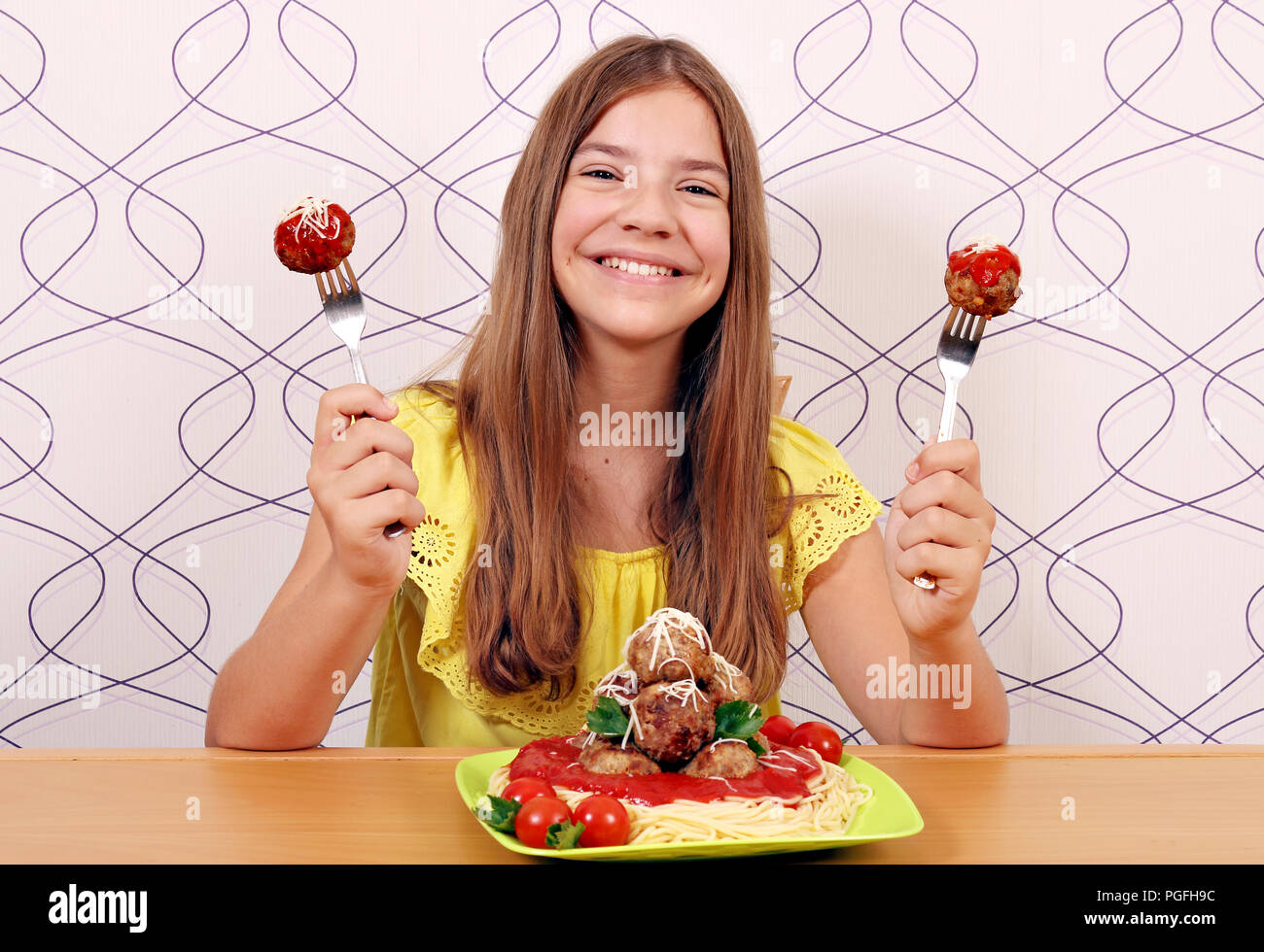 Happy girl mit Fleischbällchen und Spaghetti zum Mittagessen Stockfoto