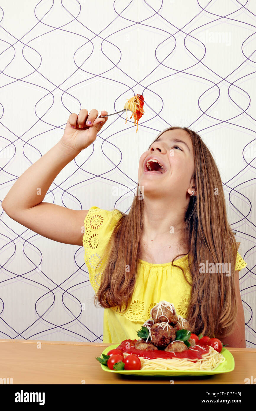 Das Mädchen isst Spaghetti mit Fleischbällchen Stockfoto