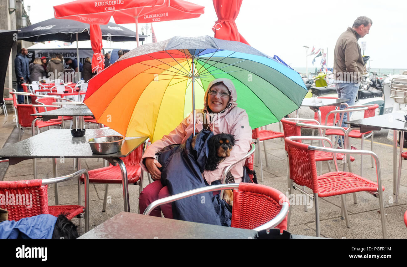 Brighton UK 26. August 2018 - Dieser Hund und Besitzer bleiben trocken auf Brighton Seafront in der Wind und der Regen da schlechtes Wetter fegt über der Südküste heute, aber die Prognose ist für es für August Bank Holiday Montag: Simon Dack/Alamy Leben Nachrichten verbessern Stockfoto