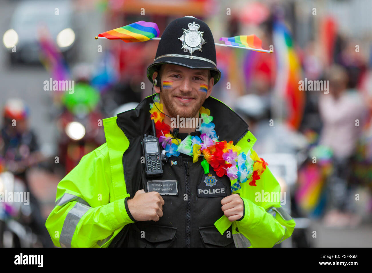 Polizeioffizier Lächeln zeigt Unterstützung auf ein stolzes Ereignis mit Stolz Fahnen und bunten Schal bekleidet, Großbritannien Stockfoto