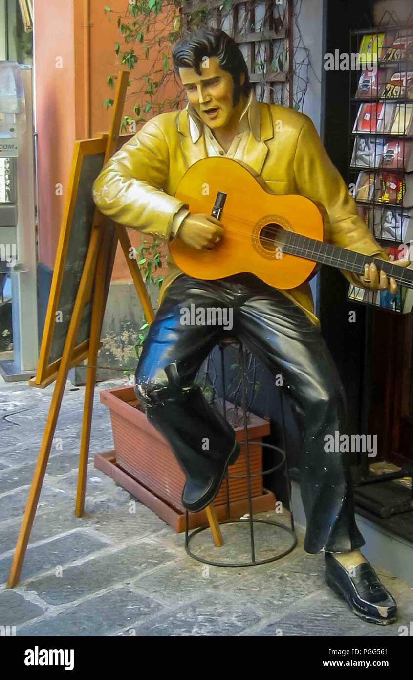 Genua, Ligurien, Italien. 16 Okt, 2004. Außerhalb ein Tourist shop in Genua, Italien, befindet sich eine Statue des berühmten amerikanischen Sänger und Schauspieler Elvis Presley seine Gitarre spielen. Genua ist ein beliebtes Ziel für Touristen und Reisende. Credit: Arnold Drapkin/ZUMA Draht/Alamy leben Nachrichten Stockfoto